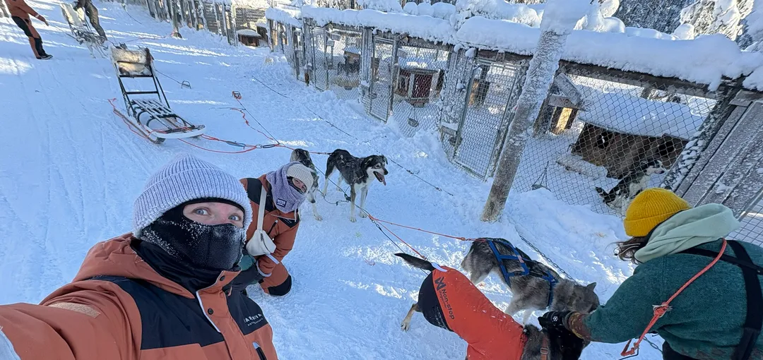 Family taking a selfie during a husky safari in Finnish Lapland