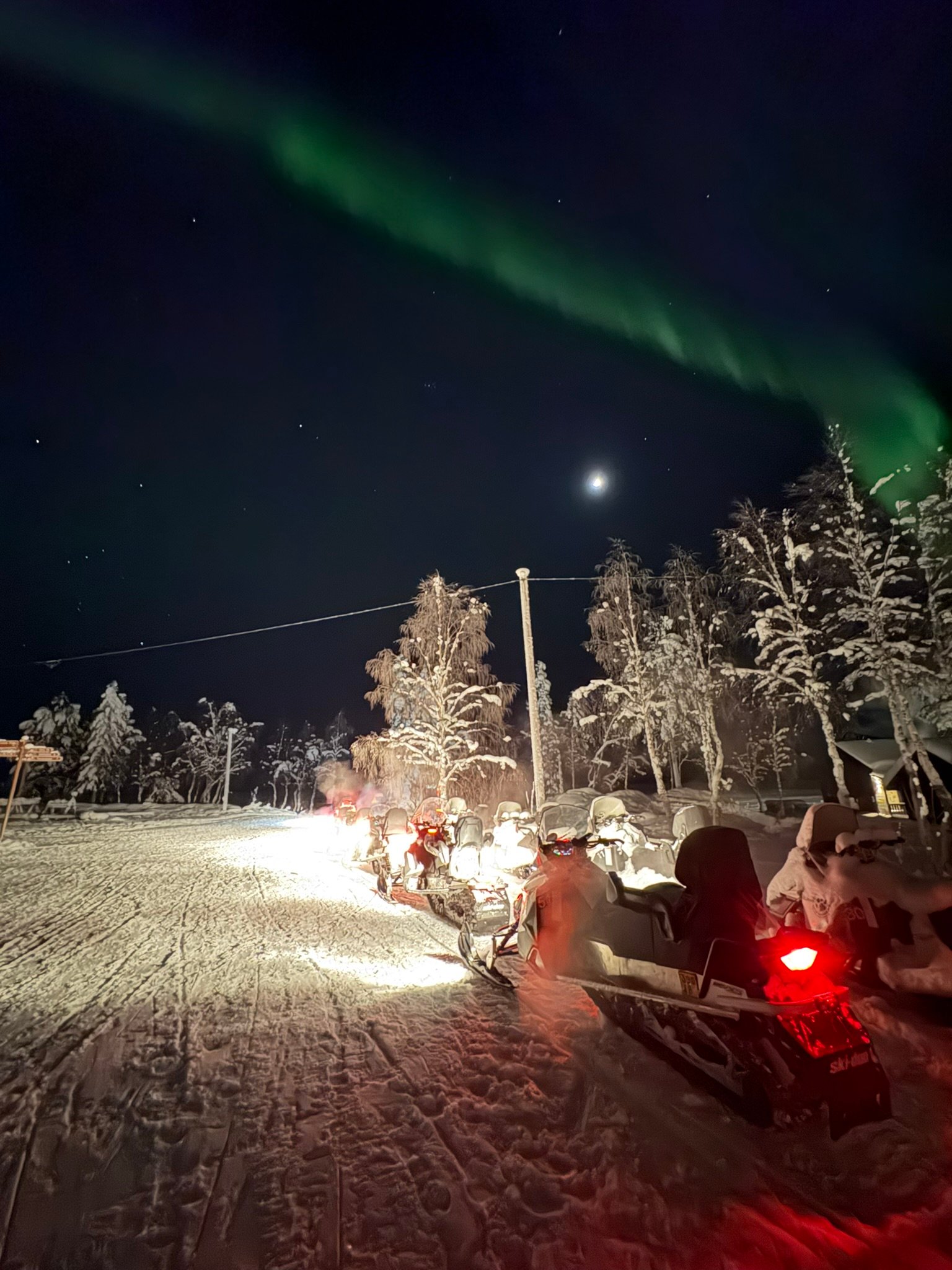 A family staying warm by a campfire while waiting for the Northern Lights to appear in Lapland