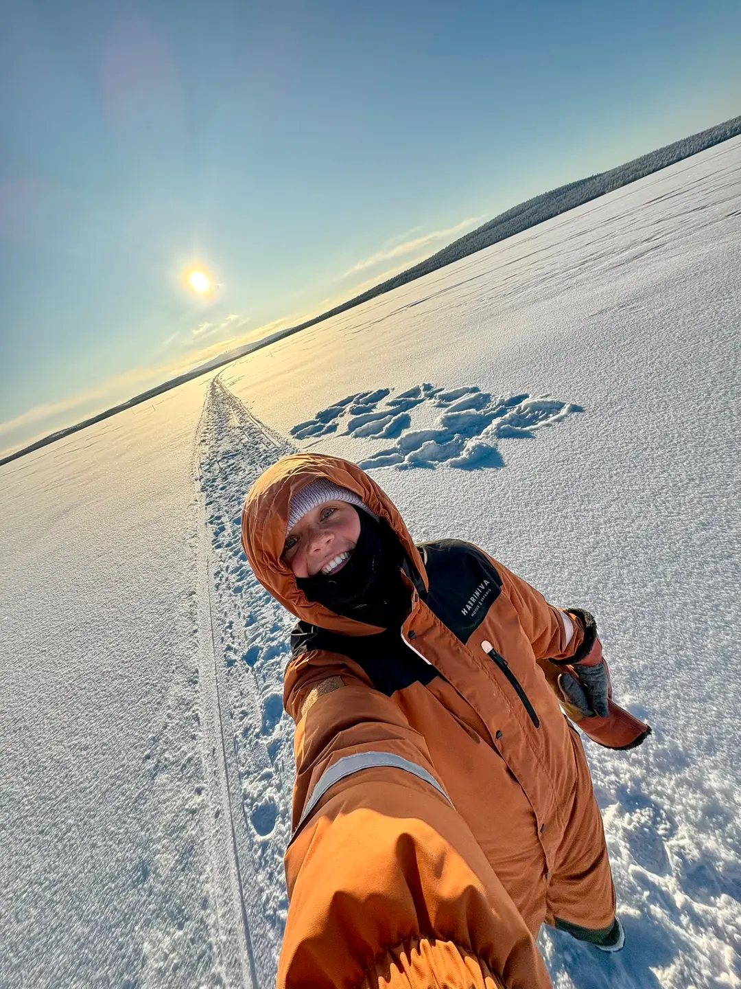 Guest selfie on a vast frozen snow-covered lake with low sun on the horizon